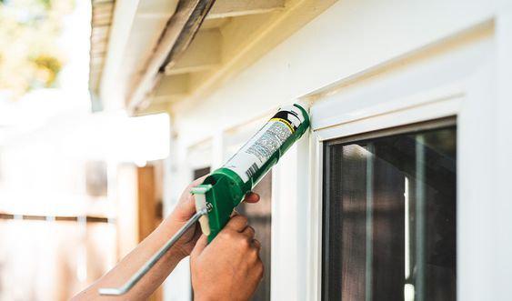 Person caulking windows