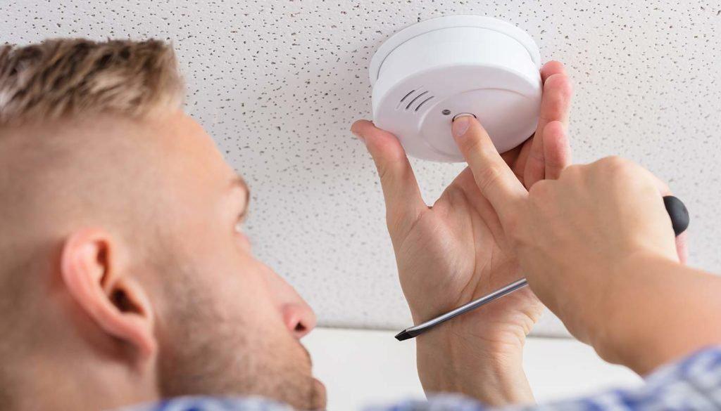 Person installing smoke detector