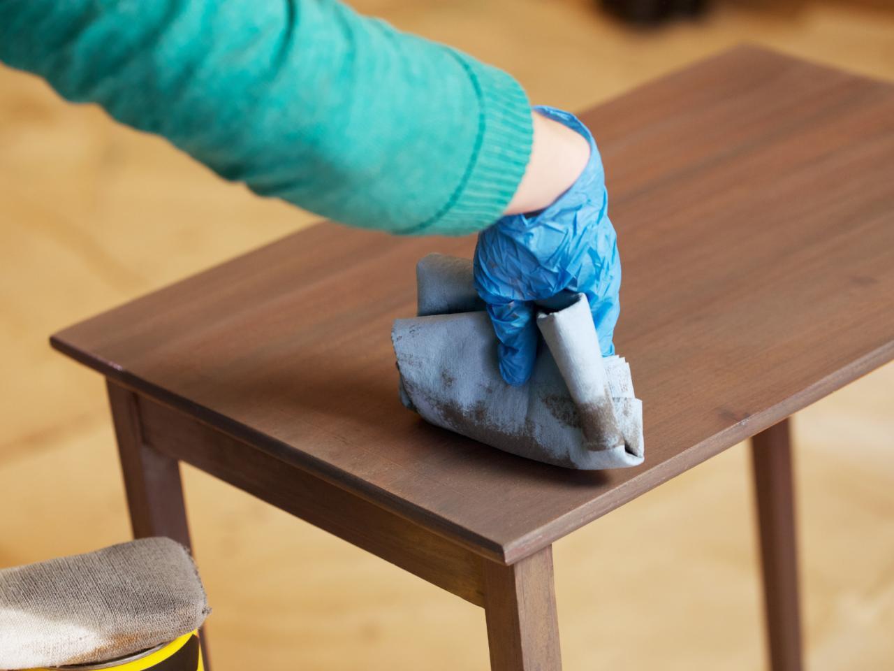Person staining wood table