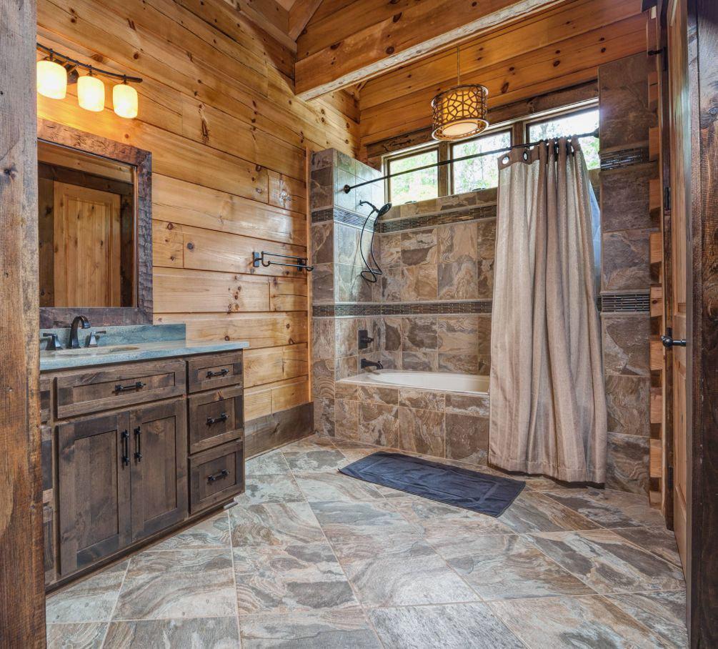 Rustic style bathroom with wooden walls and a stone shower