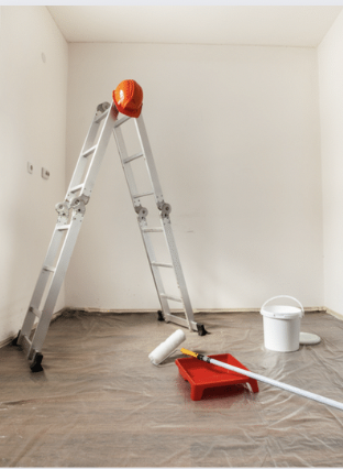 A ladder and paint supplies in room ready to be painted
