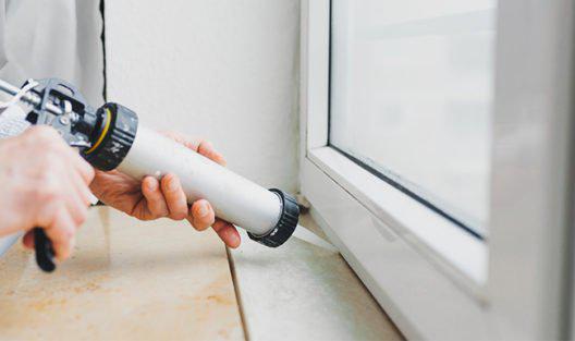 Person calking a window