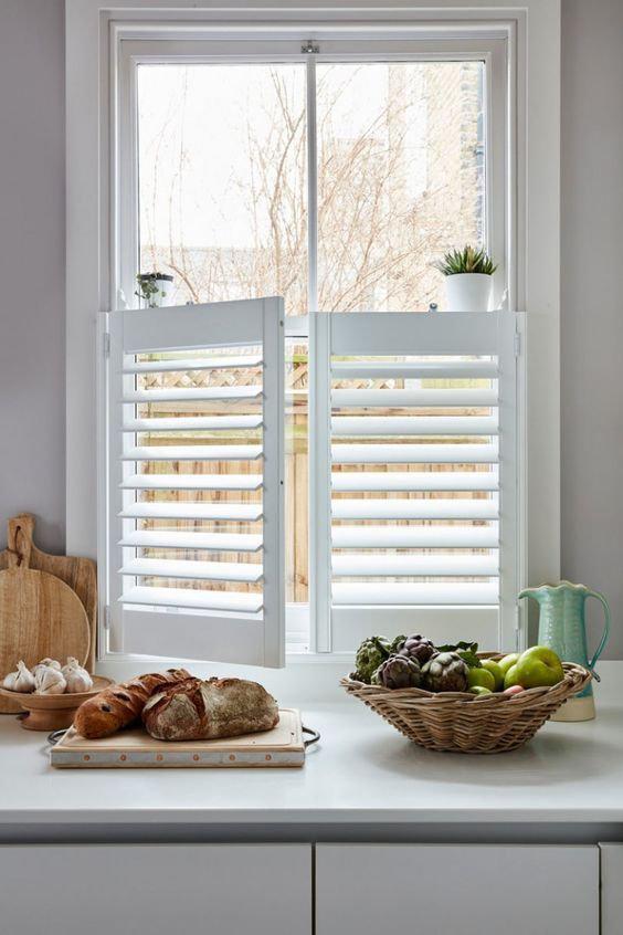 A kitchen window with shutters